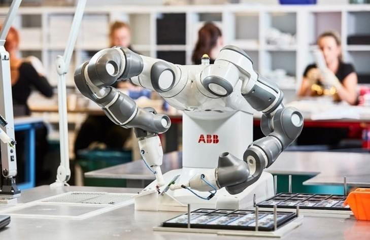 инженер программирует роботизированную линию сборки электроники